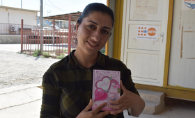سناء تحمل دفتر ملاحظات تسجل فيه أكثر ذكرياتها العزيزة على قلبها منذ وصولها إلى العراق ©صندوق الأمم المتحدة للسكان/ سلوى موسى