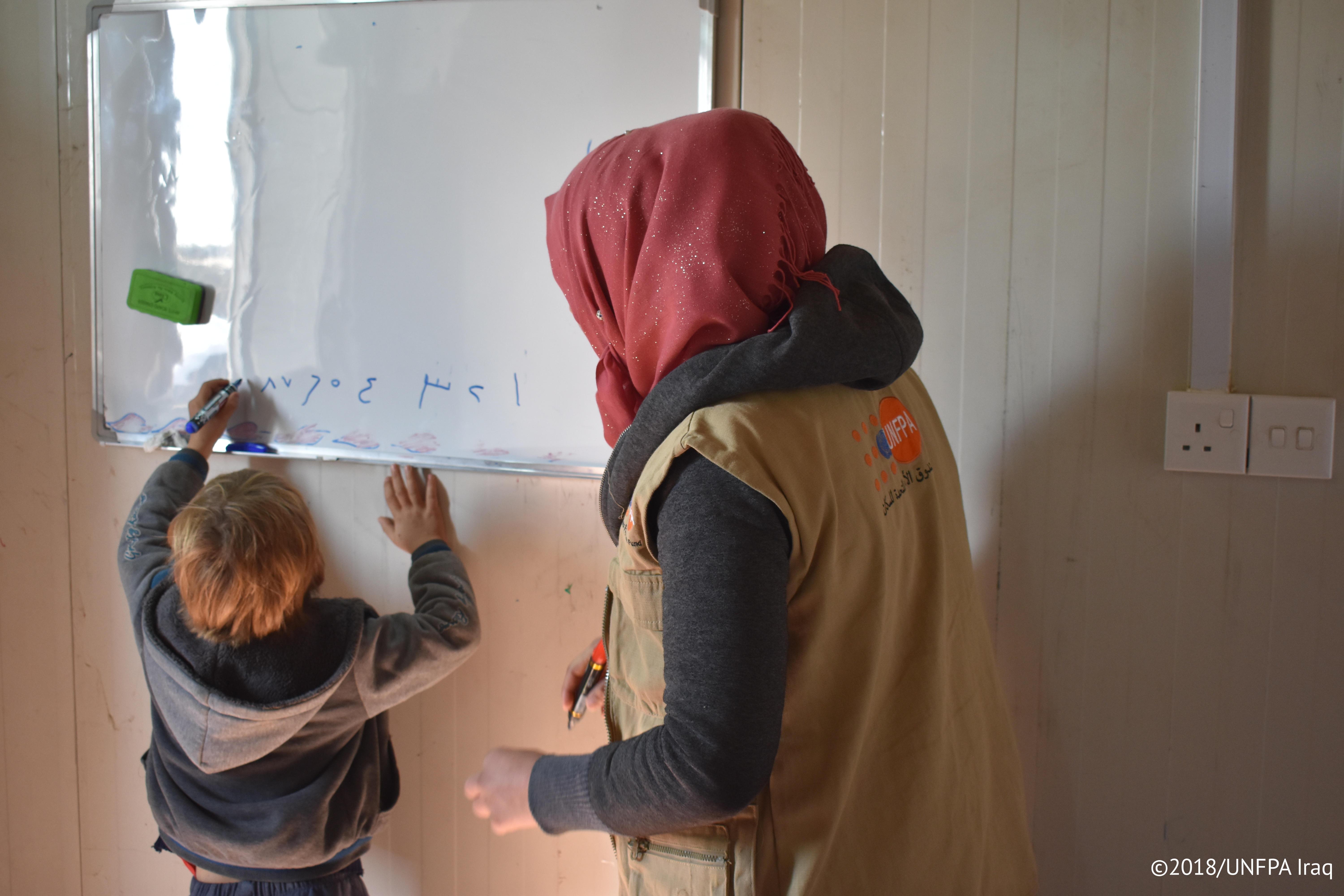 “Many women desire children, and face disappointment or even stigma if they cannot. A UNFPA-supported counselor watches over a refugee child in Iraq. © 2018/ UNFPA Iraq