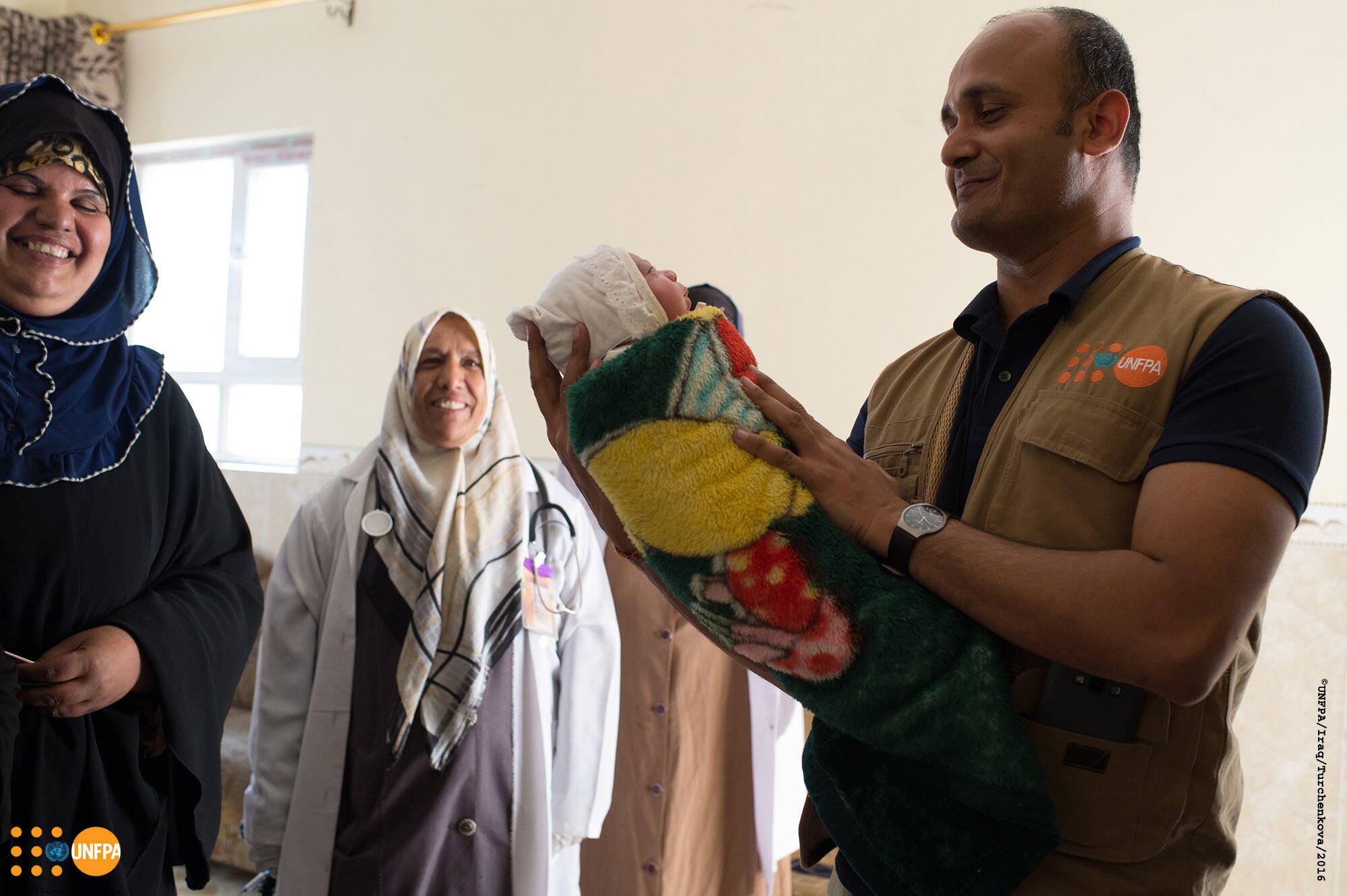 UNFPA Representative in Iraq, Ramanathan Balakrishnan, carrying a new born baby that was delivered during his field visit to Qayyarah delivery room.